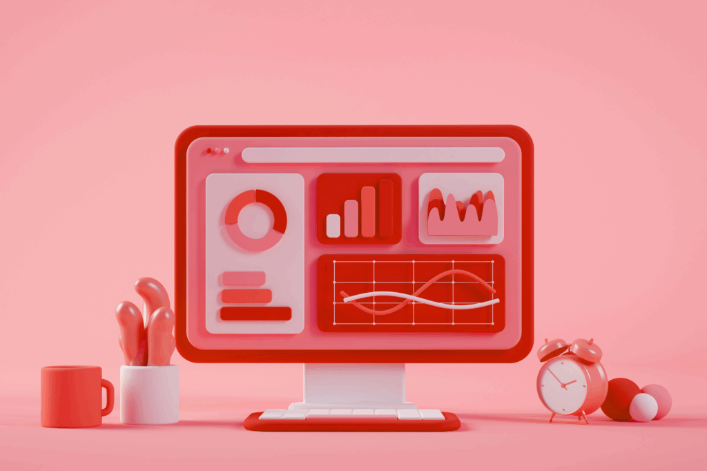 3D-rendered illustration of a desktop computer displaying colorful data charts, with surrounding objects like a mug, a plant, and an alarm clock, all in shades of red and pink.