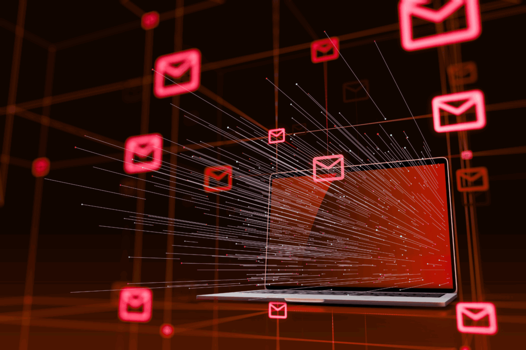 A laptop surrounded by glowing red email icons, with digital lines illustrating data flow or email traffic emerging from the screen.