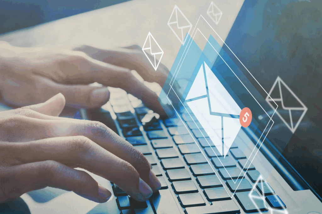 Hands typing on a laptop keyboard with digital email icons overlayed, representing new messages and email communication.