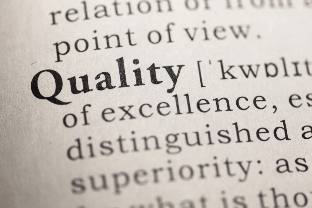 Close-up of the word "Quality" in a dictionary with its definition partially visible.